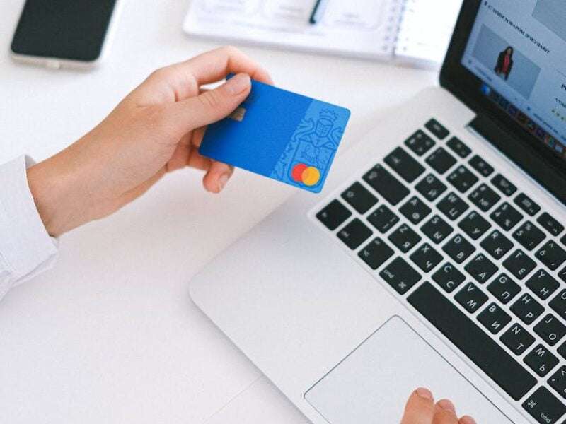 person holding credit card credit is improving