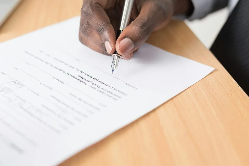 person writing on white paper signing loan what is credit